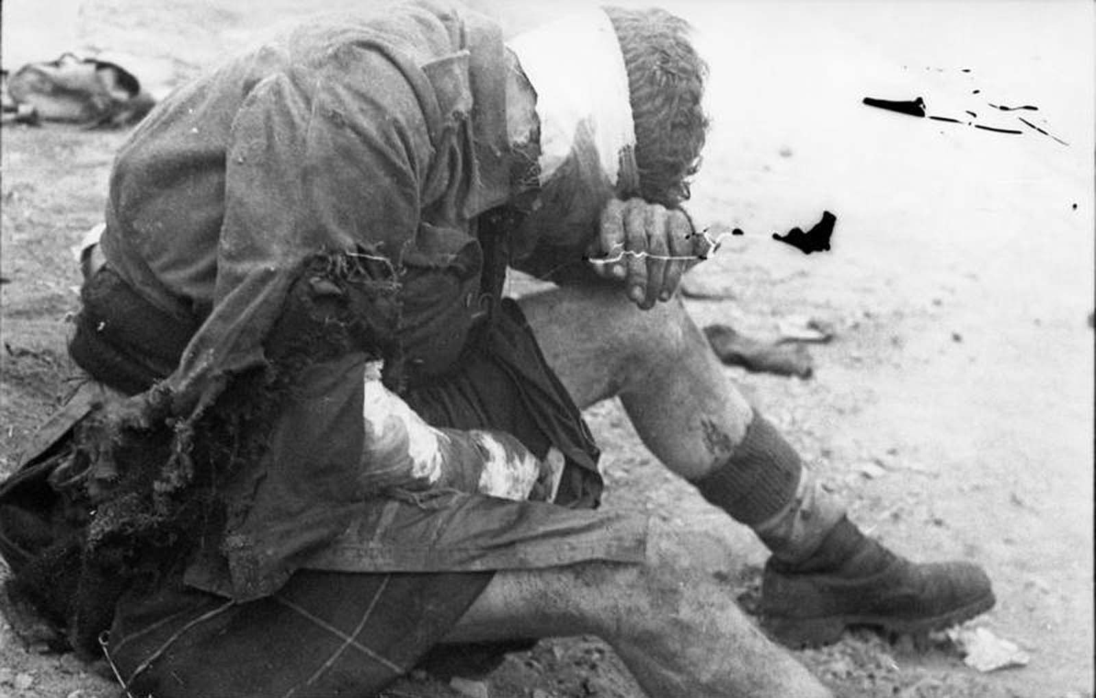 A wounded British prisoner of war, sitting on the ground in St. Nazaire, France, after the raid in March of 1942.