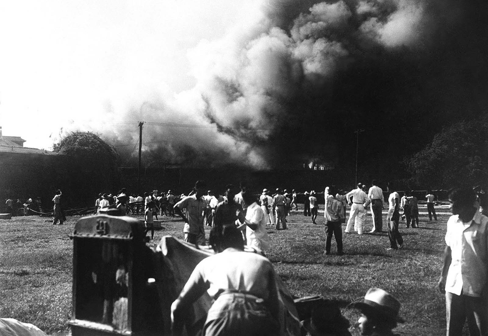 Billows of smoke from burning buildings pour over the wall which encloses Manila's Intramuros district, sometime in 1942.