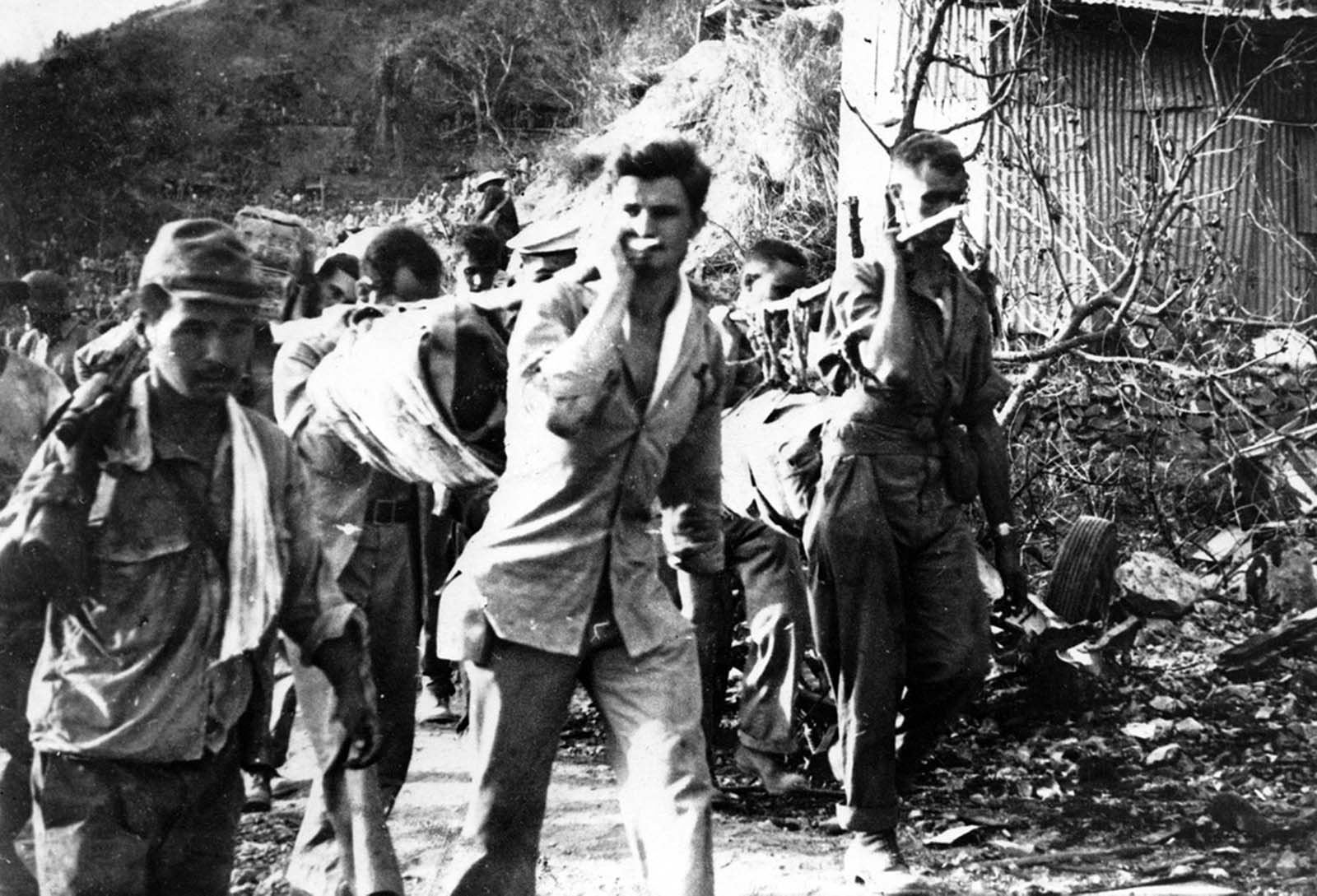 American prisoners of war carry their wounded and sick during the Bataan Death March in April of 1942. This photo was taken from the Japanese during their three year occupation of the Philippines.