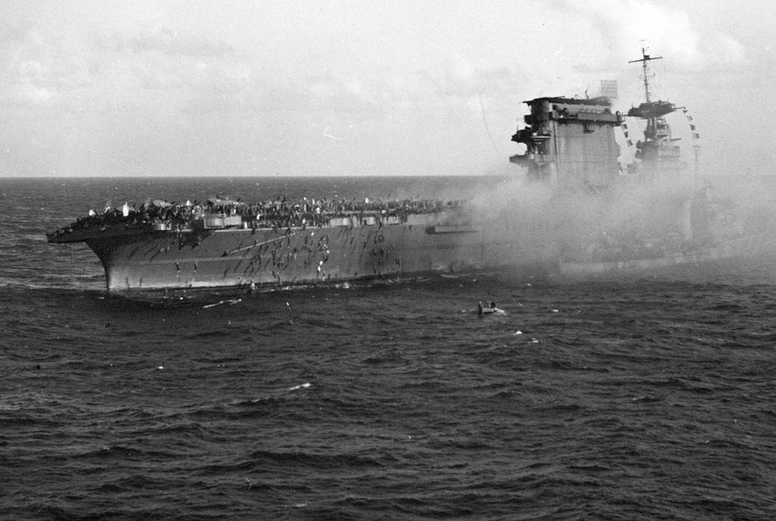 Crewmen abandon ship on board the aircraft carrier USS Lexington, after the carrier was hit by Japanese torpedoes and bombs during the Battle of the Coral Sea. Note the destroyer alongside taking on survivors. The USS Phelps eventually torpedoed the stricken carrier, scuttling it and sending it to the bottom of the sea.