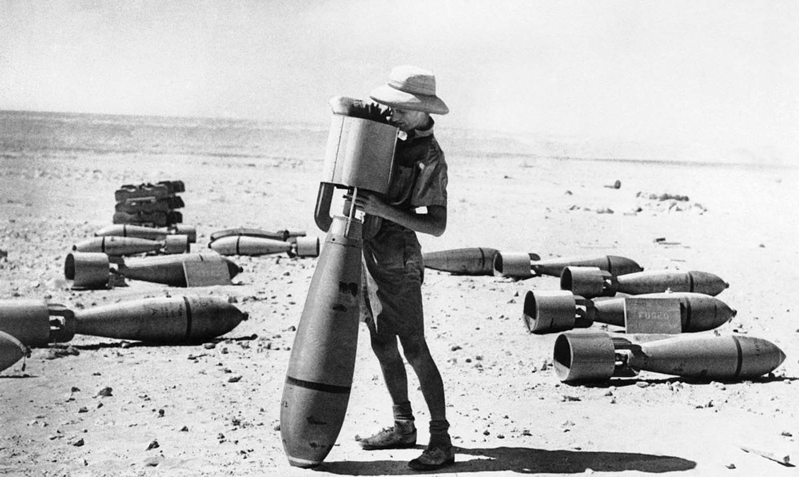 This armorer of the R.A.F.'s middle east command prepares a bomb for its mission against the Italian forces campaigning in Africa. This big bomb is not yet fused, but when it is it will be ready for its deadly work. Photo taken on October 24, 1940.