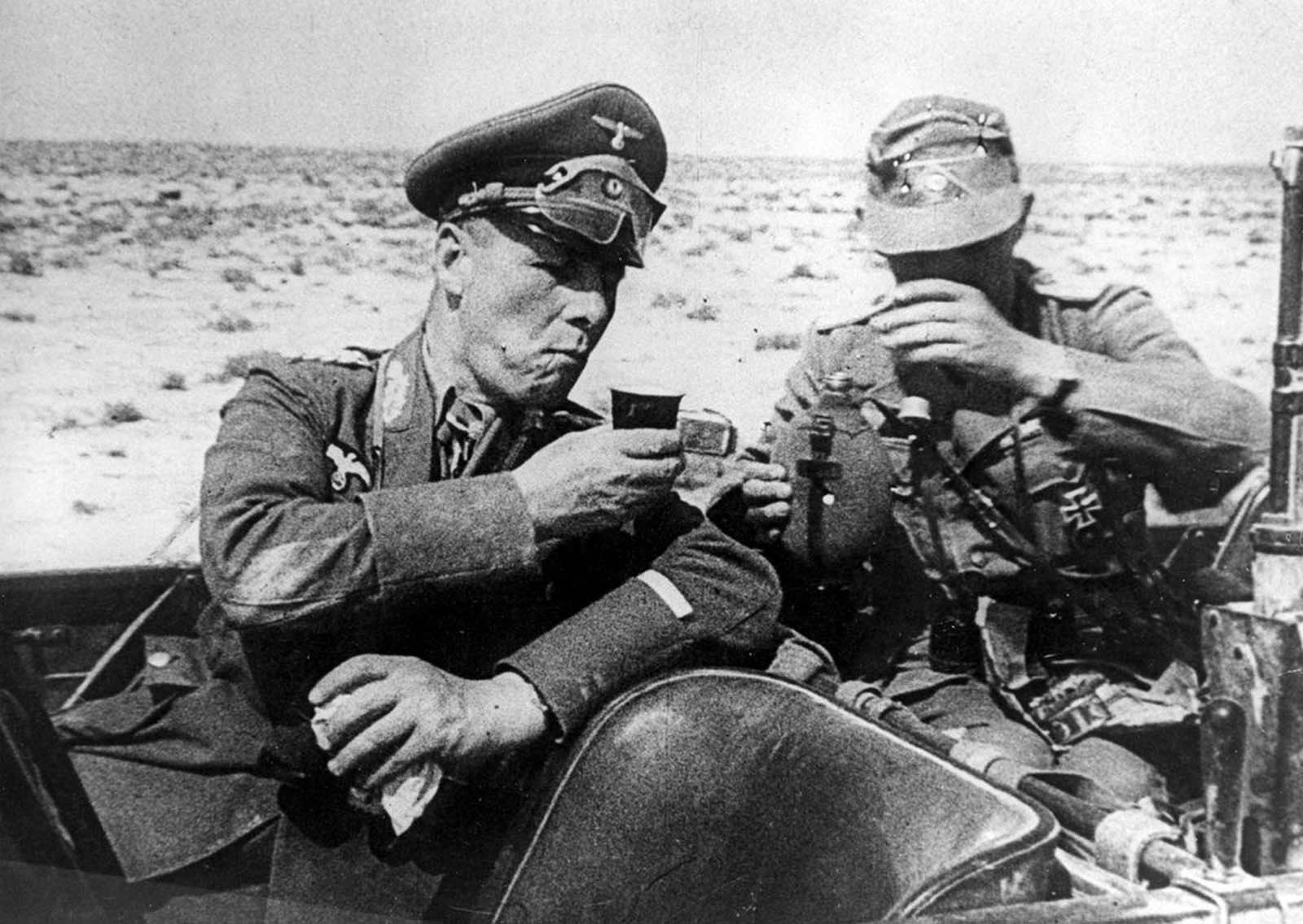 Field Marshal Gen. Erwin Rommel, commander of the German Afrika Korps, drinks out of a cup with an unidentified German officer as they are seated in a car during inspection of German troops dispatched to aid the Italian army in Libya in 1941.