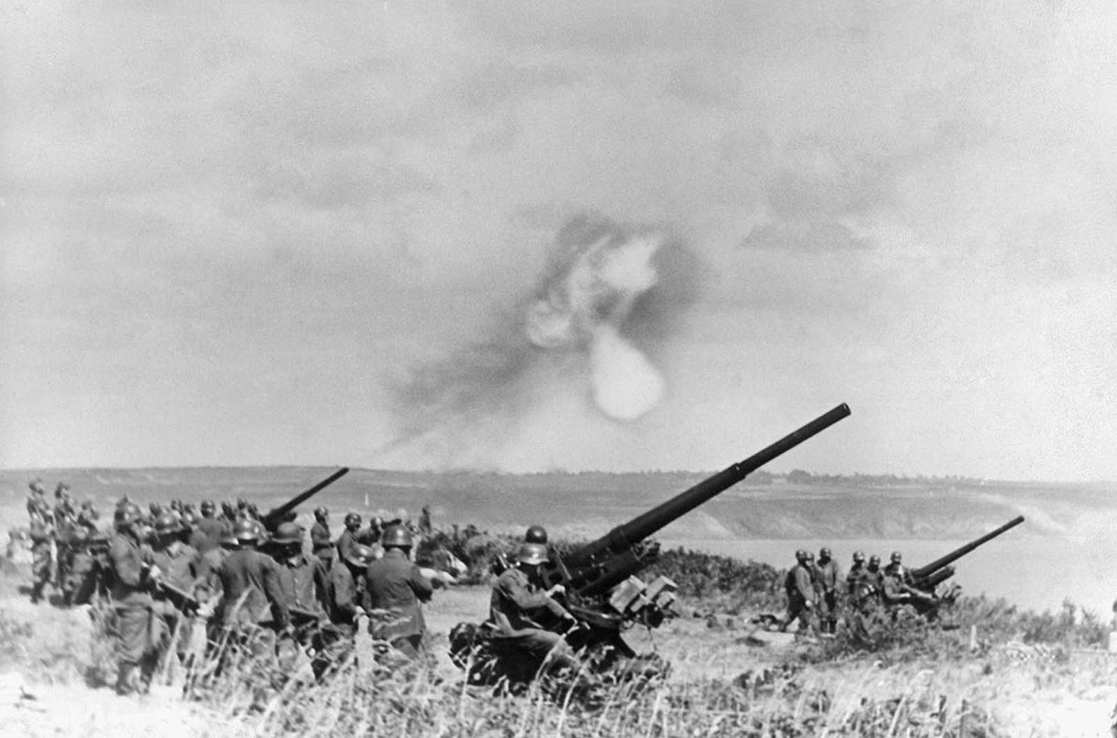 German Anti-Aircraft guns belch smoke somewhere along the Channel coast of France, on January 19, 1941.