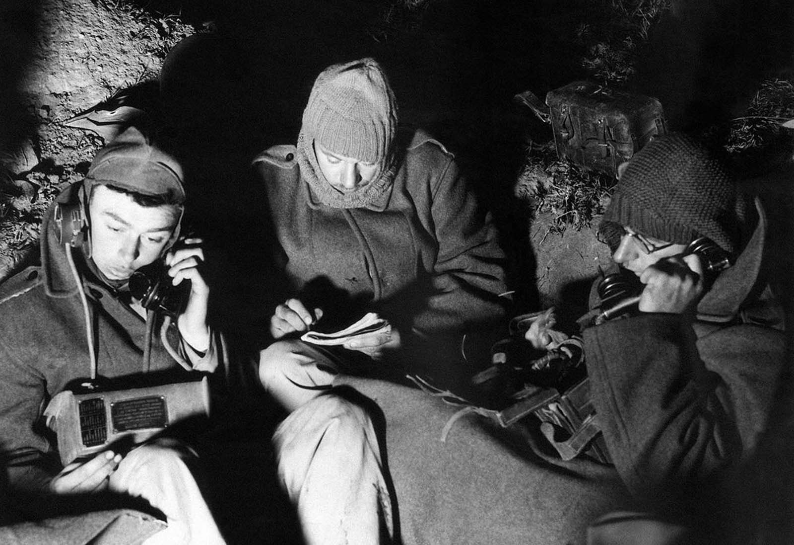Artillery Signalers at dawn in an outpost in Palestine on December 16. 1940. The men dress warmly to keep out the chill of the desert.