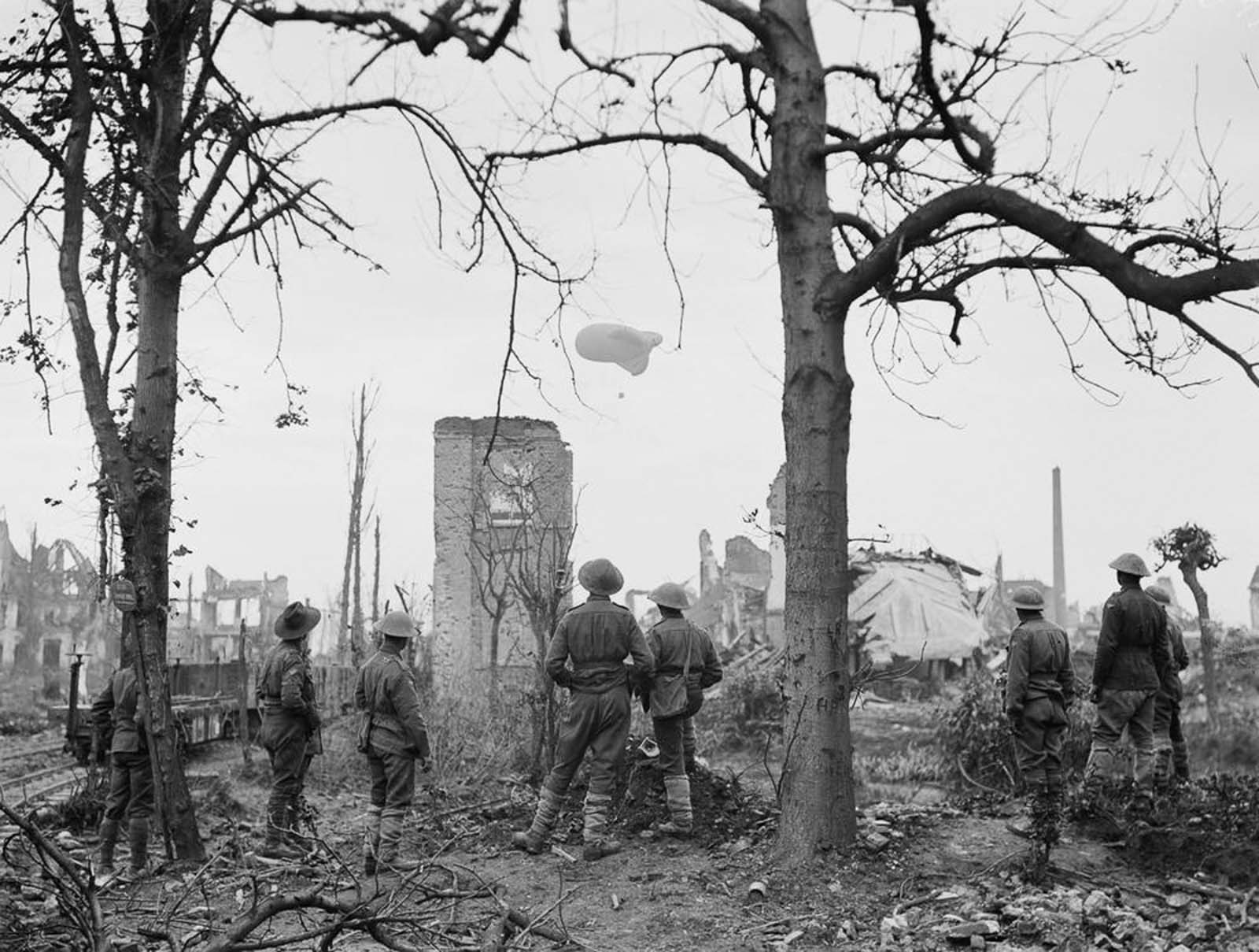 Australian soldiers watch an observation balloon ascend over Ypres, Belgium. 1917.