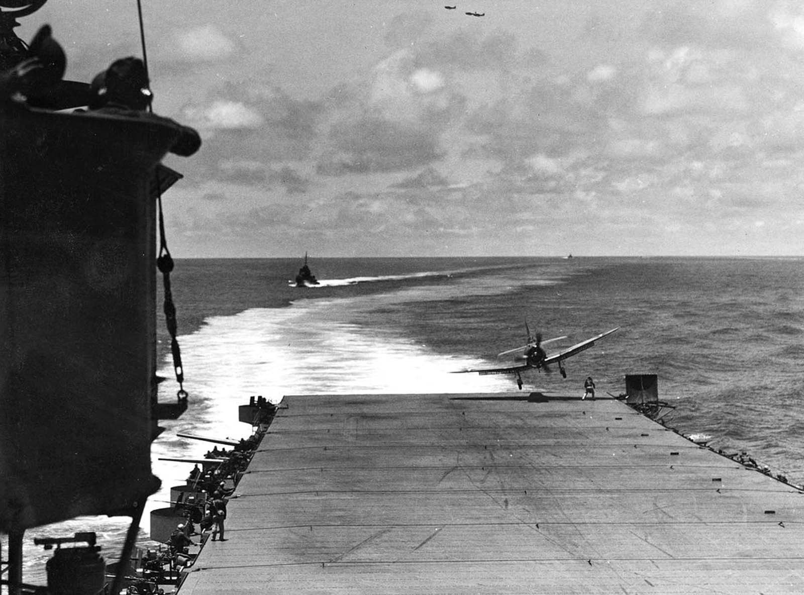 A VB-8 SBD lands far off center, flying right over the head of the Landing Signal Officer aboard USS Hornet during the Battle of Midway, on June 4, 1942.
