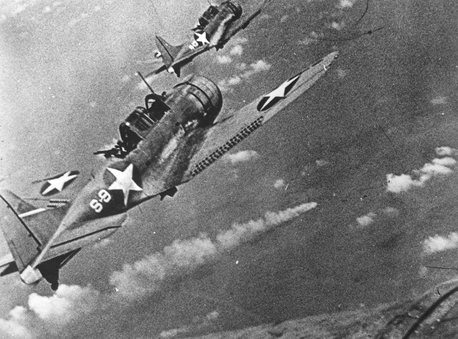 Navy fighters during the attack on the Japanese fleet off Midway, in June of 1942. At center a burning Japanese ship is visible.