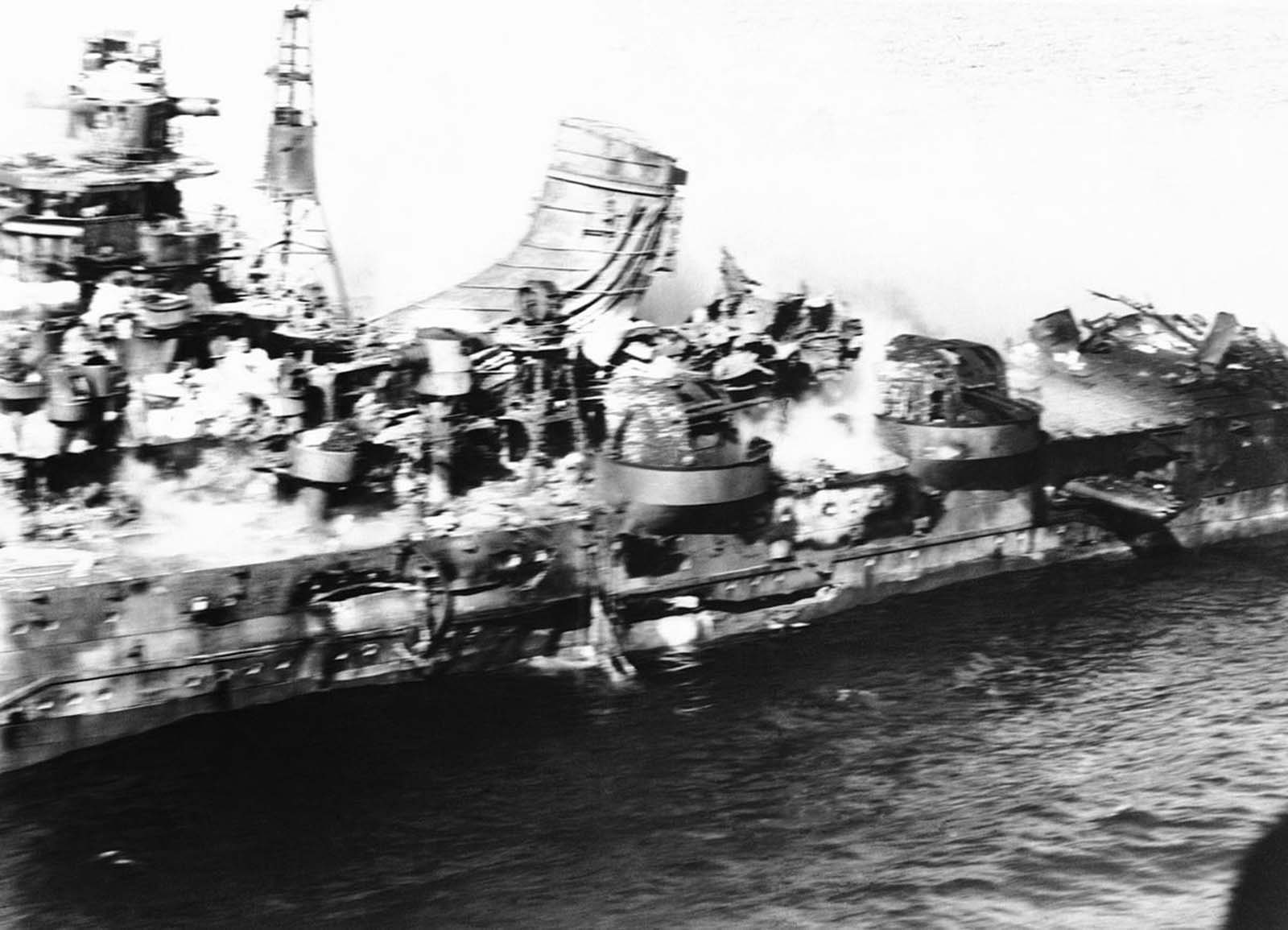 Flying dangerously close, a U.S. Navy photographer got this spectacular aerial view of a heavy Japanese cruiser of the Mogima class, demolished by Navy bombs, in the battle of Midway, in June of 1942. Armor plate, steel decks and superstructure are a tumbled mass.