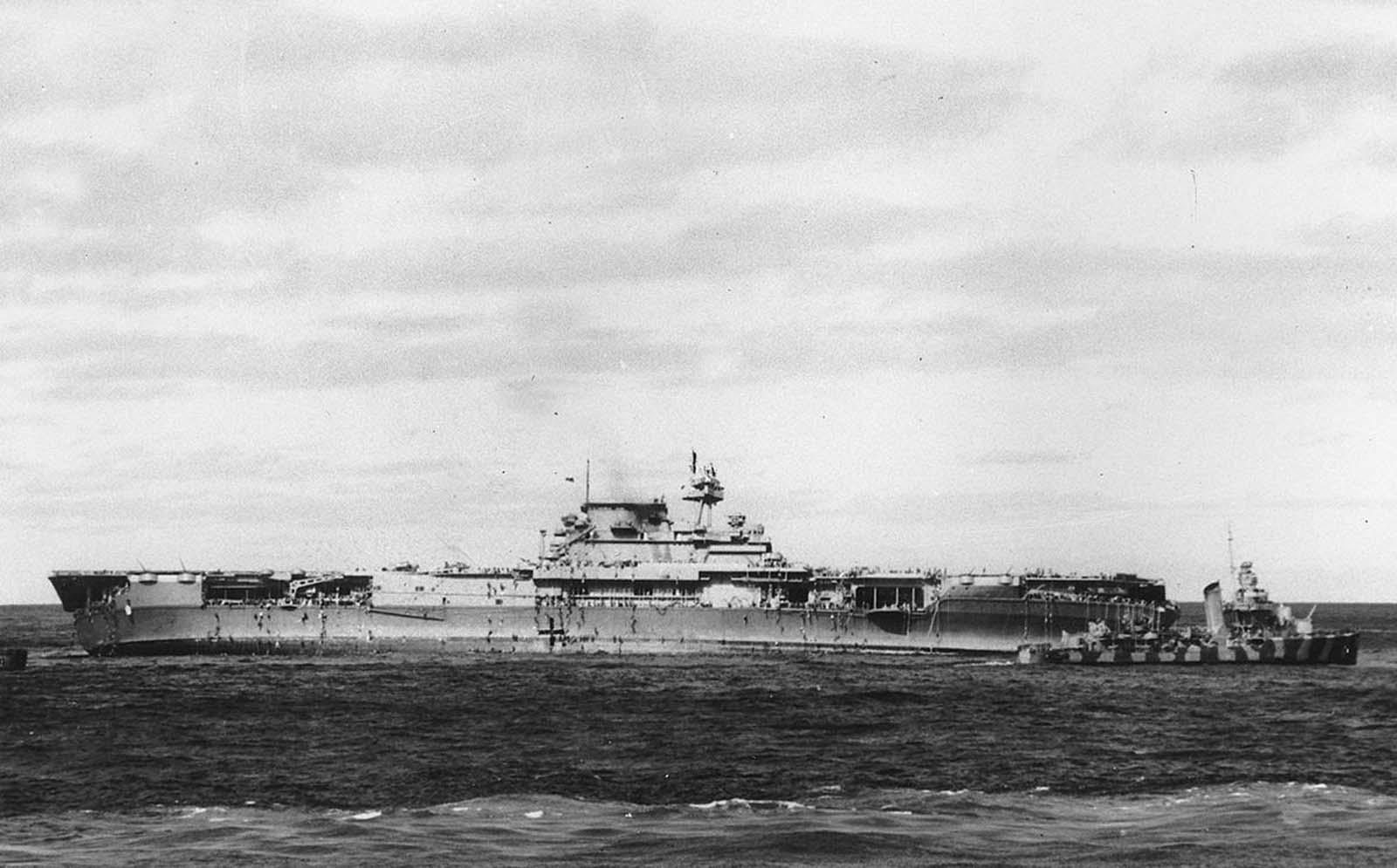 After Japanese bombers damaged the USS Yorktown, crewmen climb down ropes and ladders to small boats that transferred them to rescue ships, including the destroyer at right, on June 4, 1942 in the Pacific Ocean. Later, a salvage crew returned to the abandoned ship and as she made progress toward port, a torpedo from a Japanese submarine destroyed and sank the Yorktown.