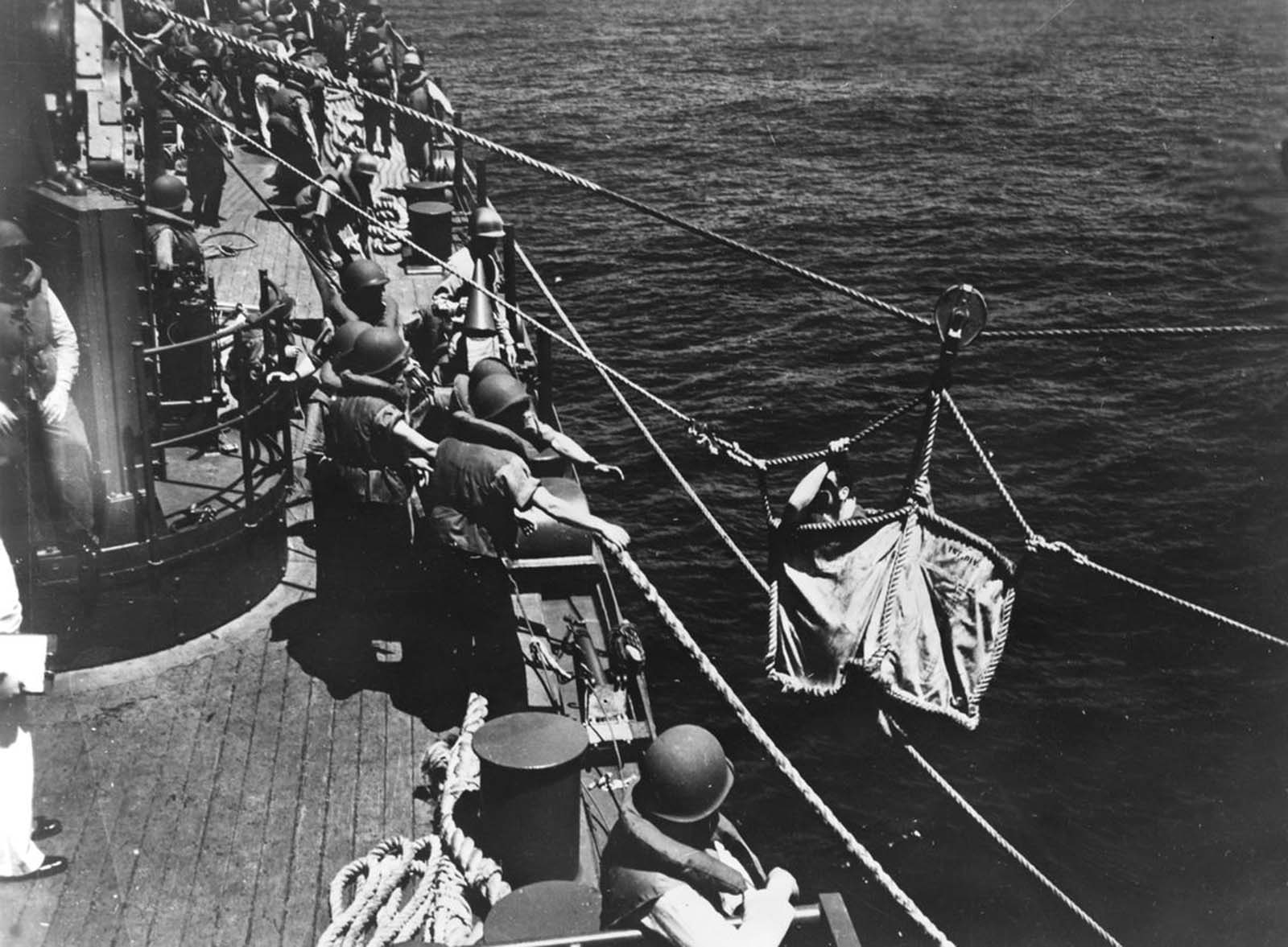 A U.S. seaman, wounded during the Battle of Midway, is transferred from one warship to another at sea in June of 1942.