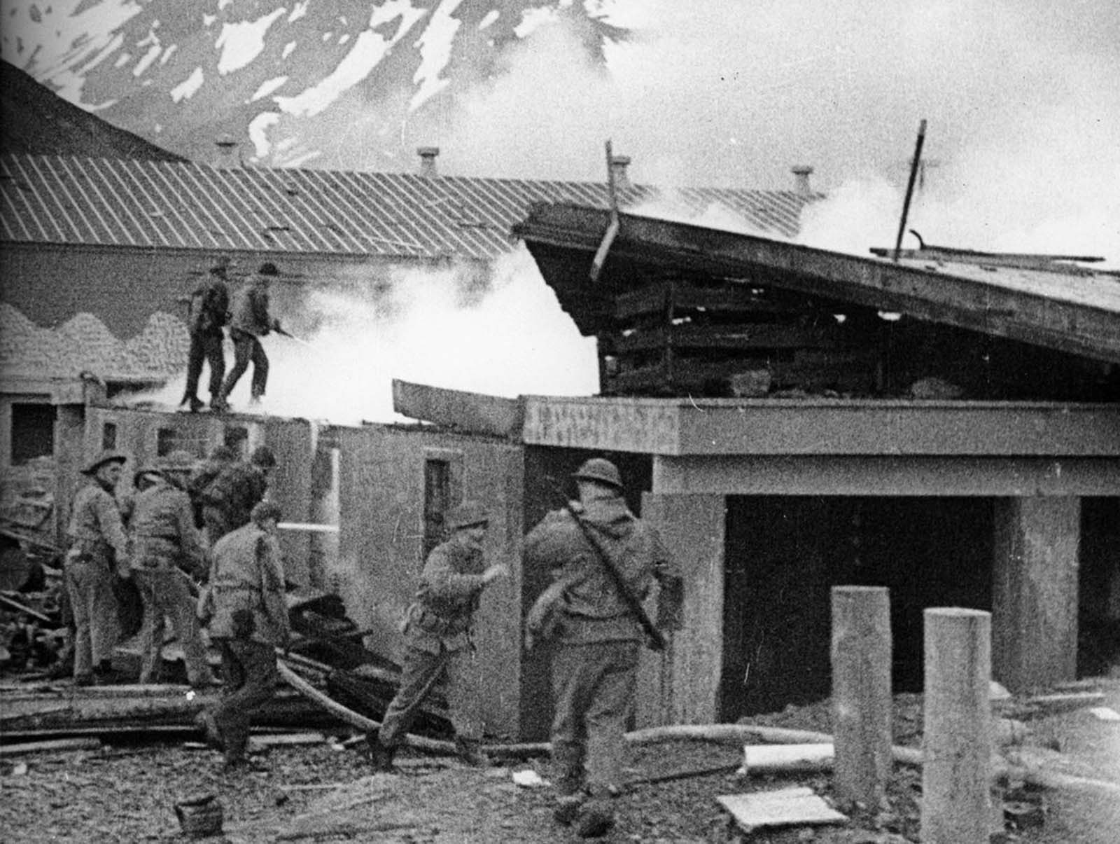 U.S. soldiers fight a fire after an air raid by Japanese dive bombers on their base in Dutch Harbor, Alaska, in June 1942.