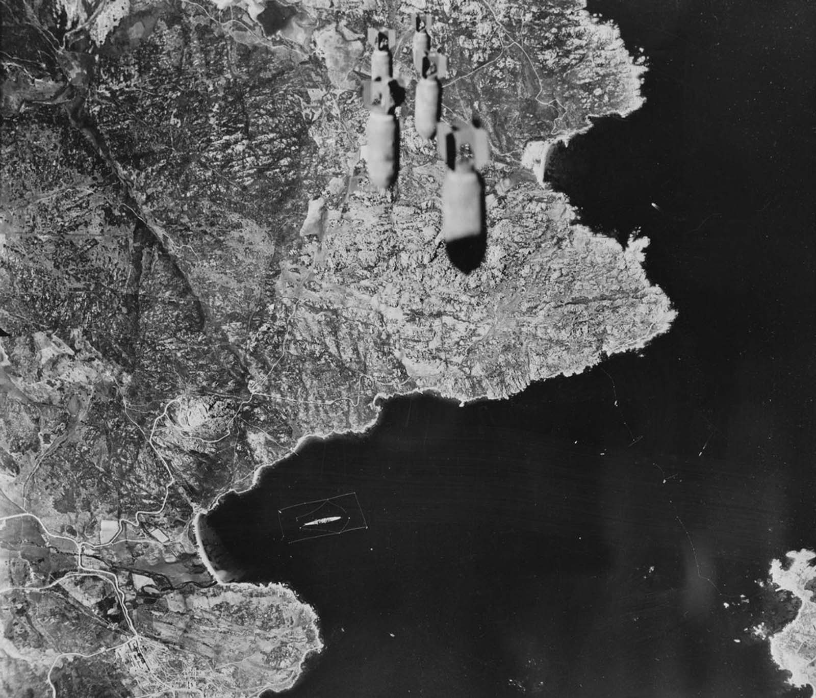 A train of bombs drops from United States Army Air forces plane on territory in the Aleutians held by the Japanese in 1943.