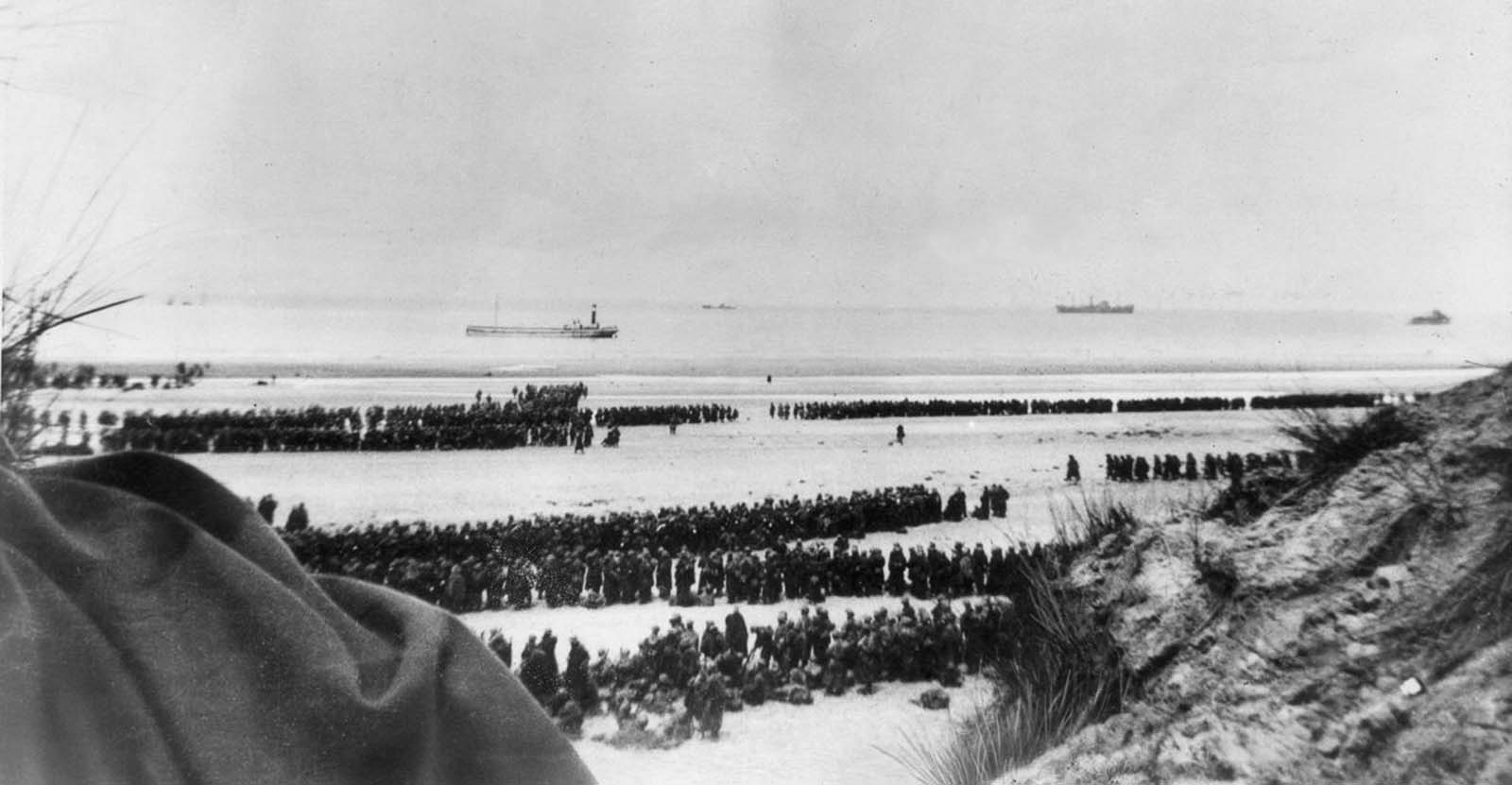 British and French troops await evacuation on the beach at Dunkirk.
