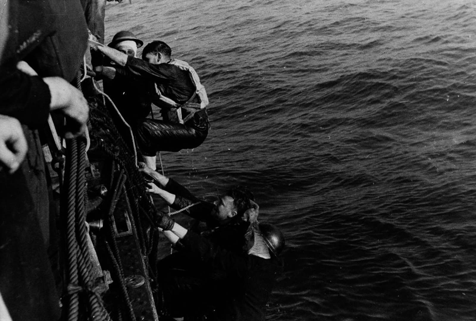 A British ship rescues soldiers from a landing craft sunk during the evacuation.