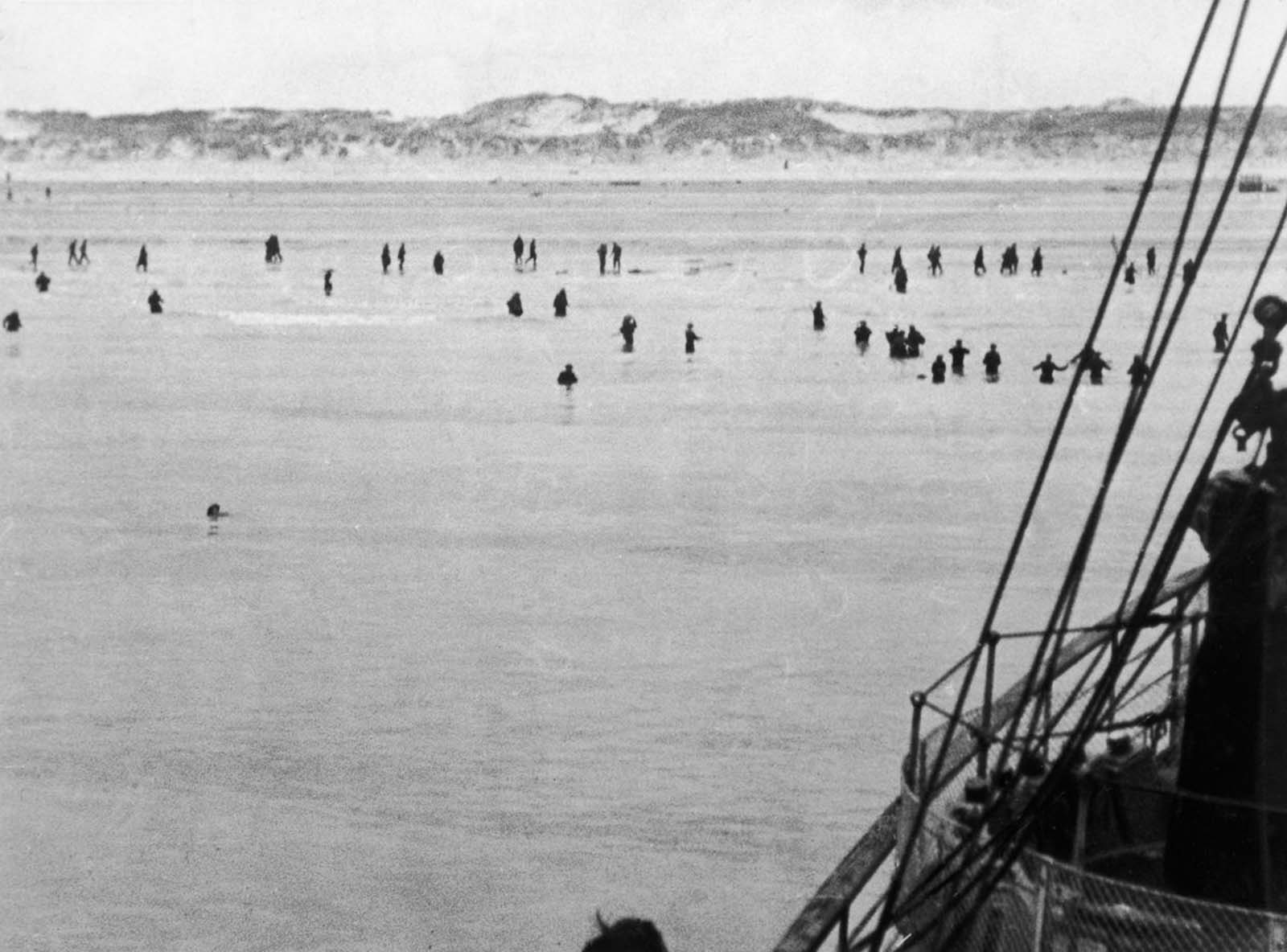 British and French troops wade out to evacuation ships off Dunkirk beach.