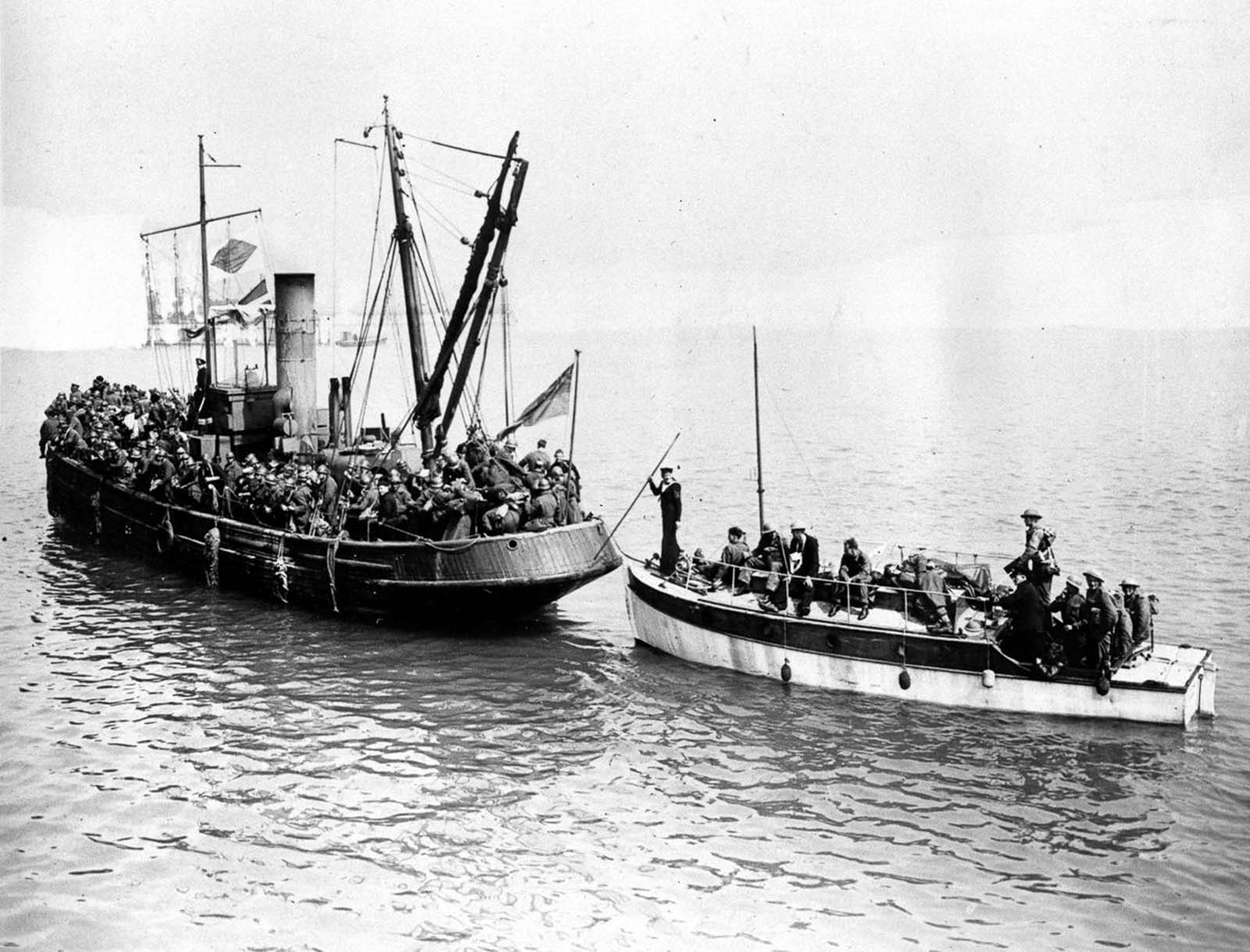 Some of the last troops to be evacuated crowd aboard two civilian boats.