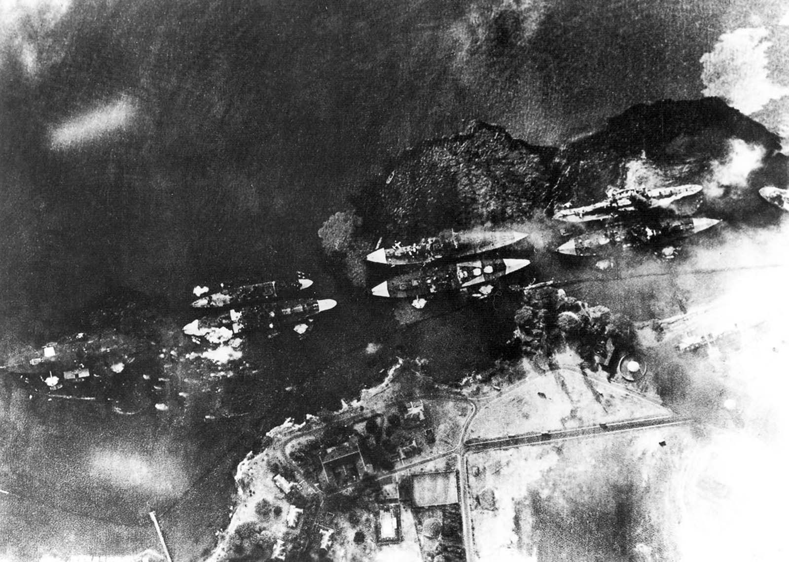 An image taken by a Japanese bomber shows ships burning and oil spreading across the surface of the harbor.