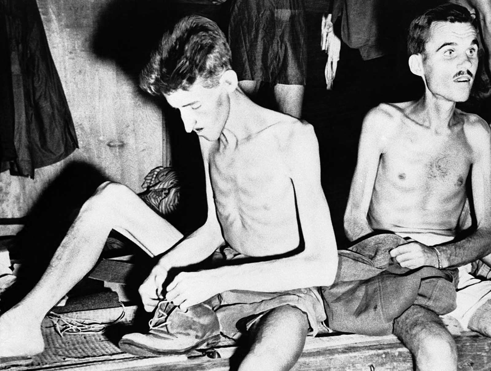 Gaunt and emaciated, but happy at their release from Japanese captivity, two Allied prisoners pack their meager belongings, after being freed near Yokohama, Japan, on September 11, 1945, by men of an American mercy squadron of the U.S. Navy.