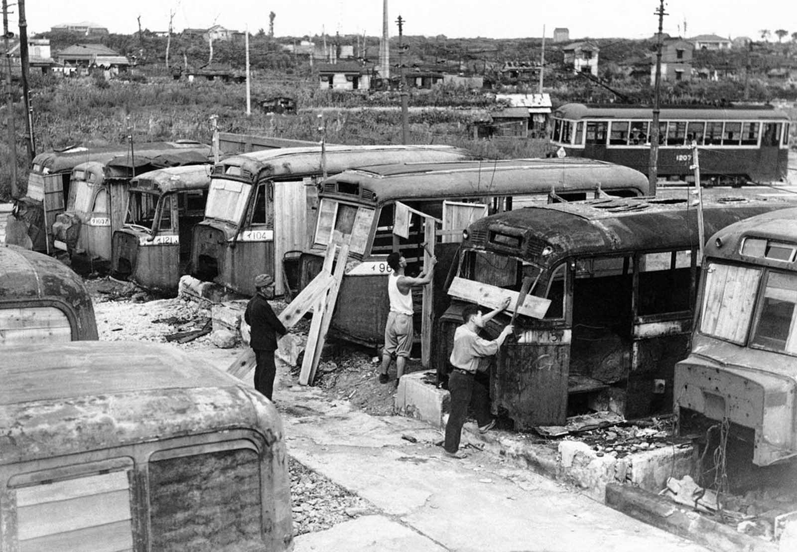 Disabled buses that have littered the streets of Tokyo are used to help relieve the acute housing shortage in the Japanese capital on October 2, 1946. Homeless Japanese who hauled the buses into a vacant lot are converting them into homes for their families.
