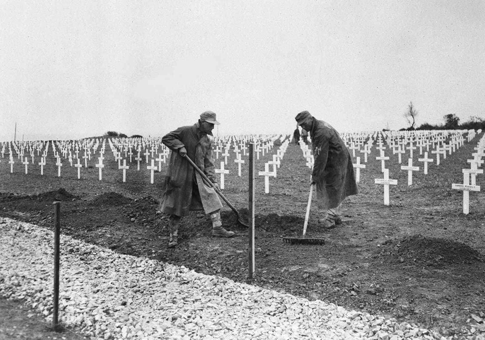 One year after the D-Day landings in Normandy, German prisoners landscape the first U.S. cemetery at Saint-Laurent-sur-Mer, France, near