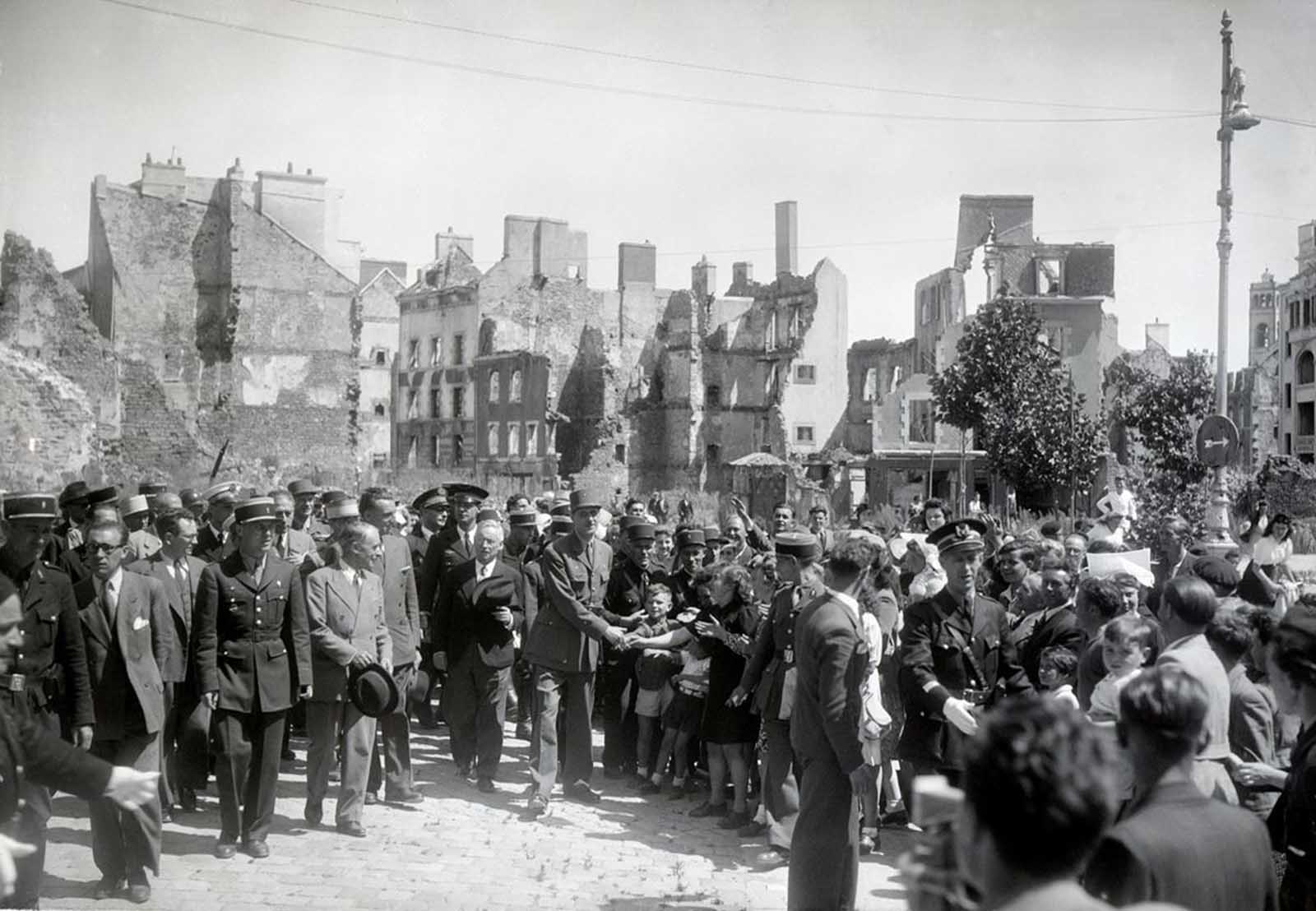 General Charles de Gaulle (center) shaking hands with children, two months after the German capitulation in Lorient, France, in July of 1945. Lorient was the location of a German U-boat (submarine) base during World War II. Between January 14 and February 17, 1943, as many as 500 high-explosive aerial bombs and more than 60,000 incendiary bombs were dropped on Lorient. The city was almost completely destroyed, with nearly 90% of the city flattened.