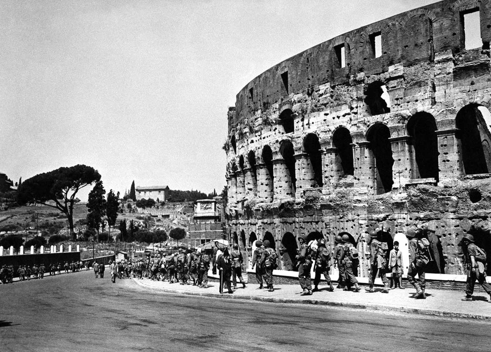 U.S. soldiers march past the historical Roman Colosseum and follow their retreating enemy in Rome, Italy, on June 5, 1944.