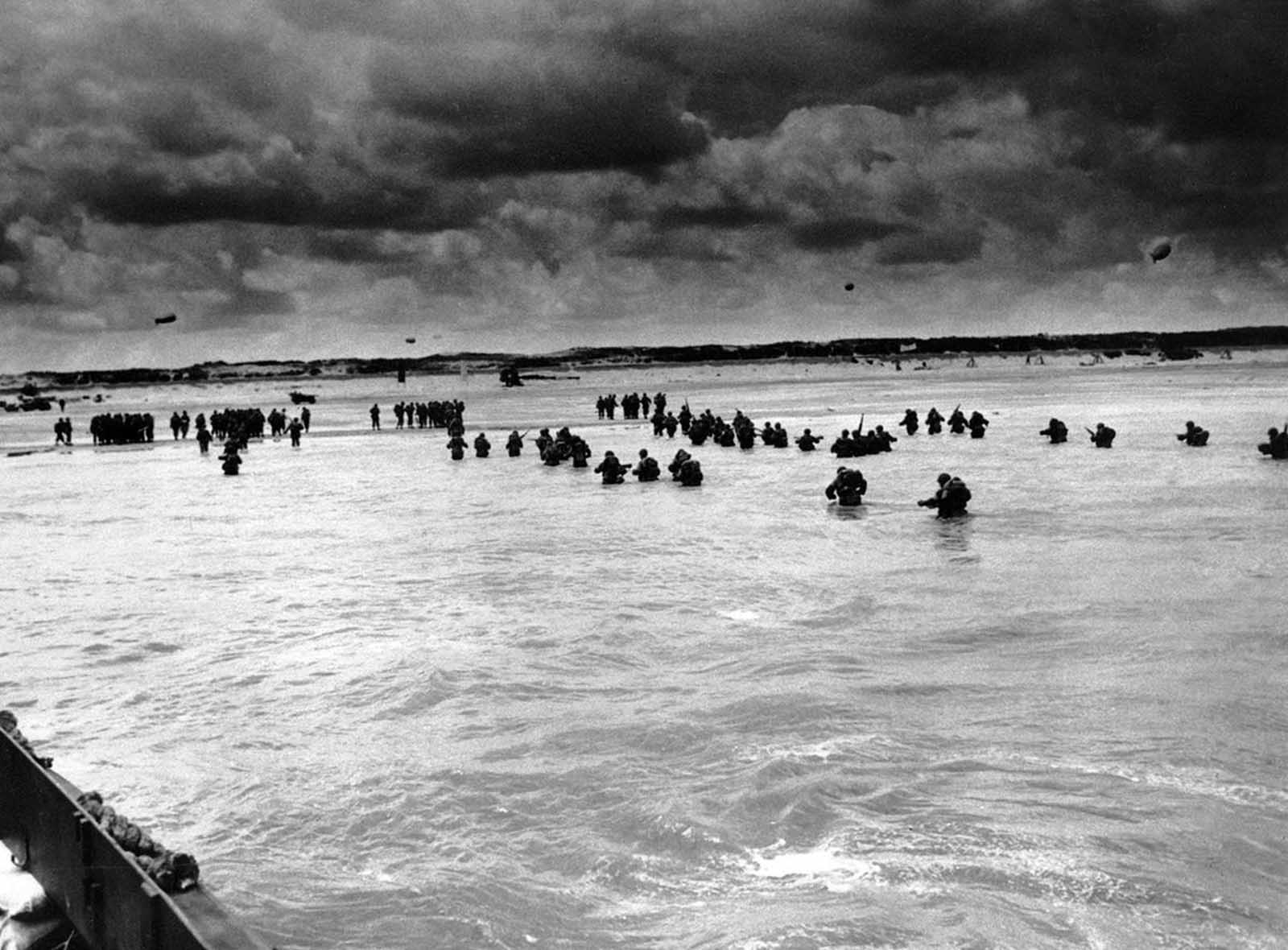 U.S. reinforcements wade through the surf as they land at Normandy in the days following the Allies' June 1944 D-Day invasion of France.