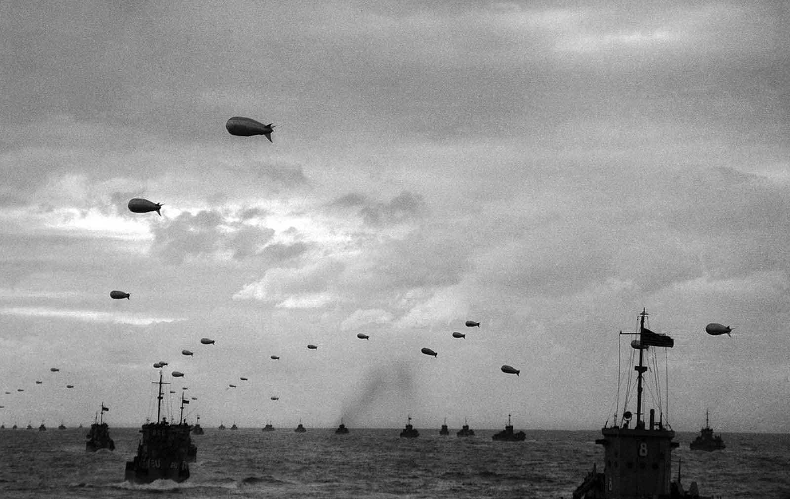 A section of the Armada of Allied landing craft with their protective barrage balloons head toward the French coast, in June of 1944.