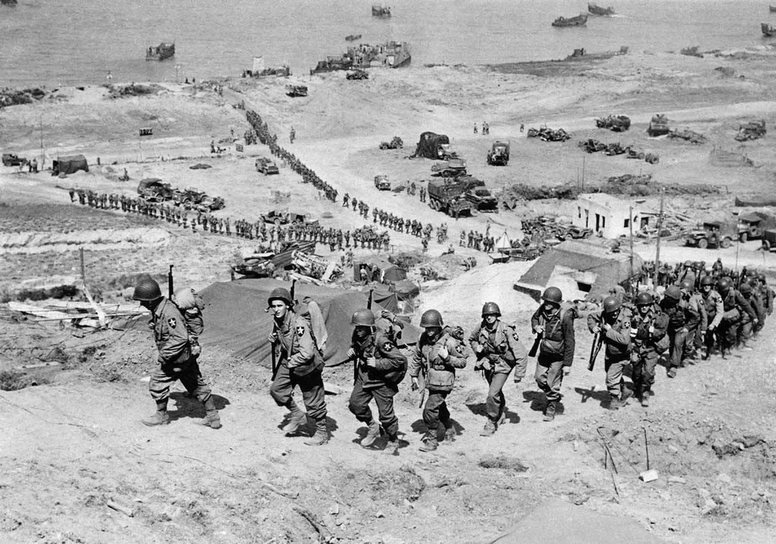 Reinforcements for initial allied invaders of France, long lines of troops and supply trucks begin their march on June 18, 1944, in Normandy.