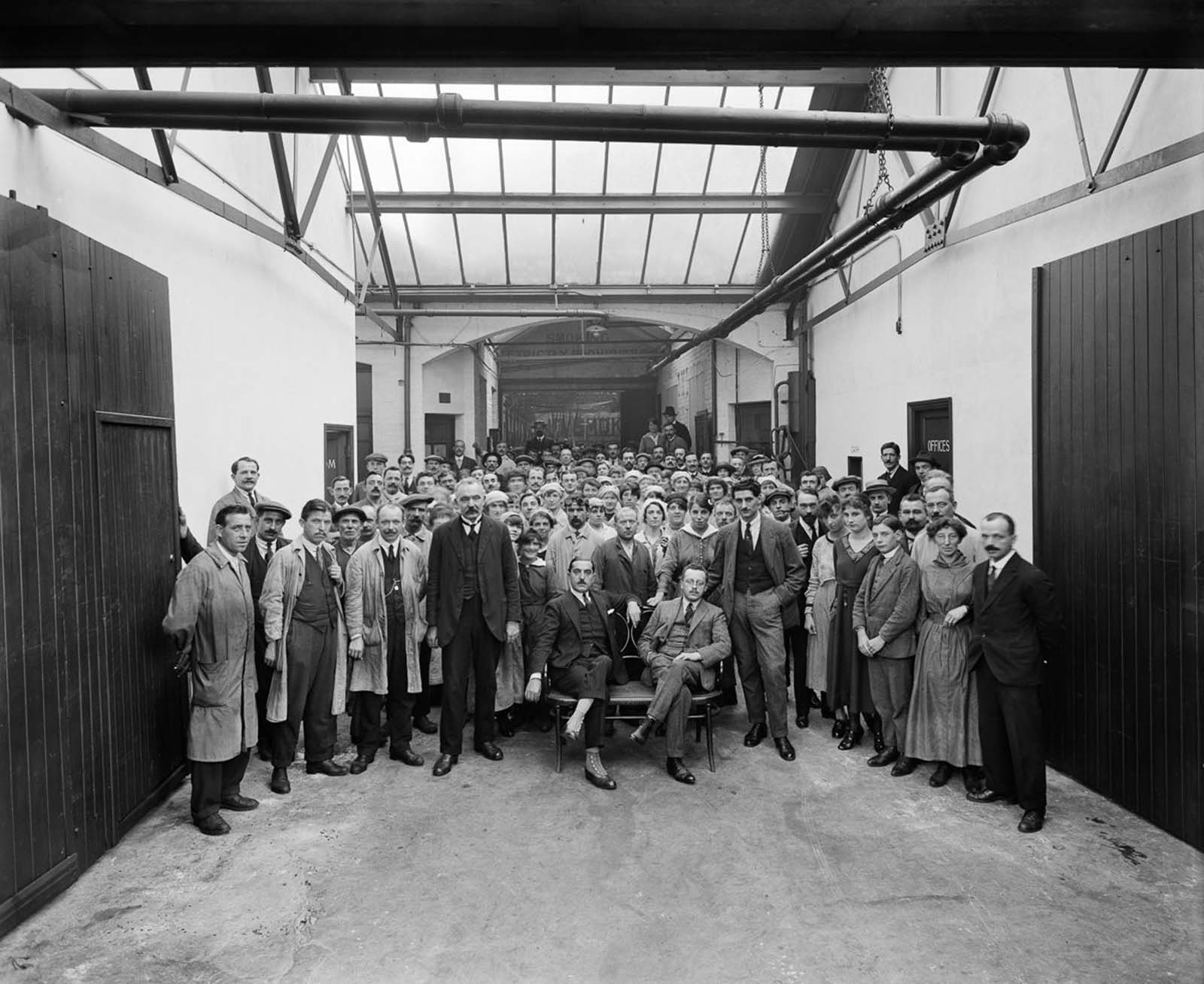 A group portrait of the managers and workers in the Belgian Munition Works in London, which employed Belgian refugees to manufacture grenades and artillery shells for the war effort. 1918.