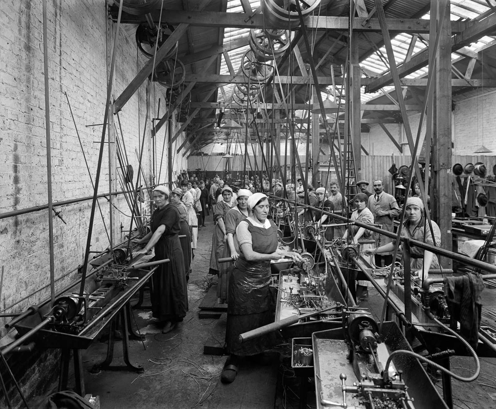 Belgian refugee women use lathes to make ammunition casings at the Belgian Munition Works in London.