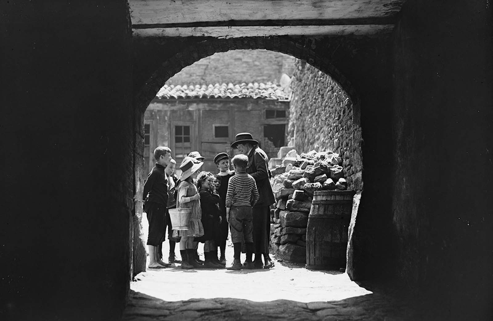 A visitor from the Red Cross Bureau of Refugees inquires into the needs of children in the tenements, in which refugees are housed, on July 16, 1918.