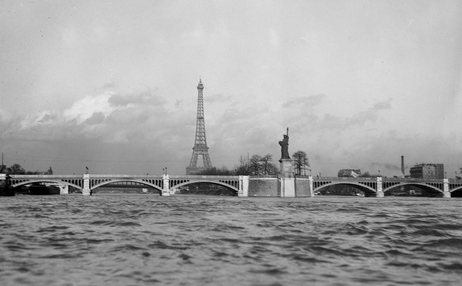 The Eiffel Tower and a replica of the Statue of Liberty on Île aux Cygnes in Paris in March of 1919.