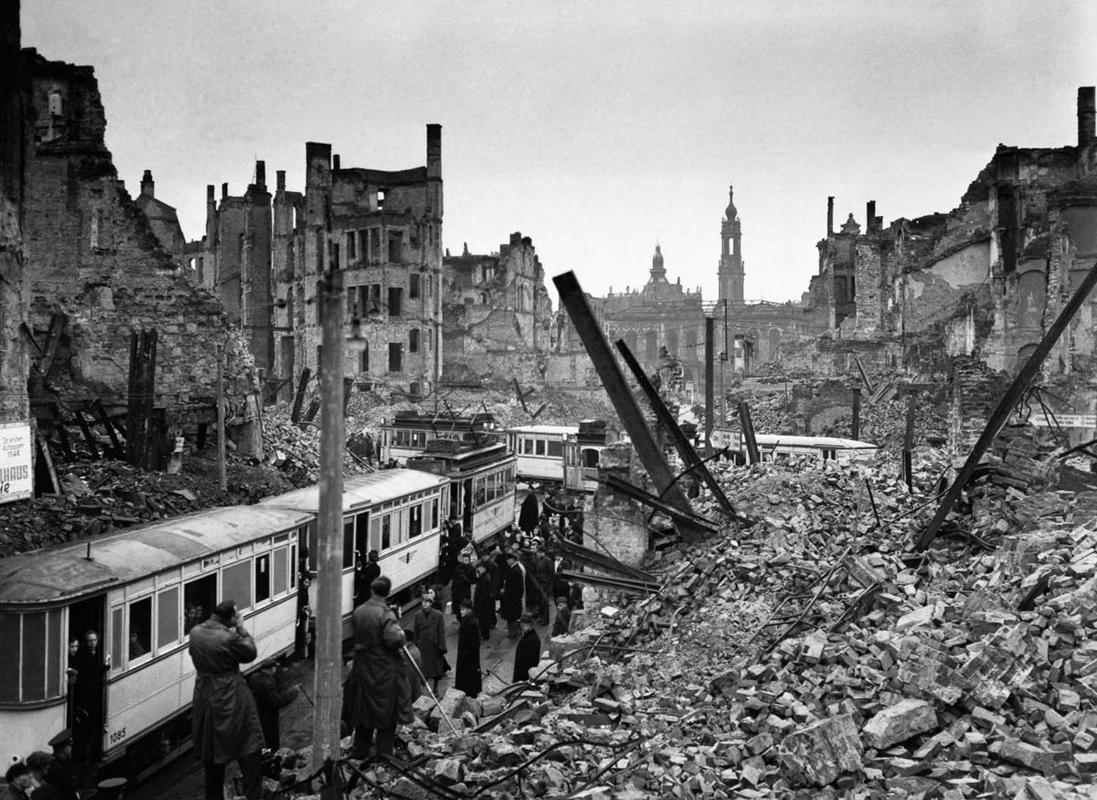 Residents ride trams through the rubble of the city. 1946.