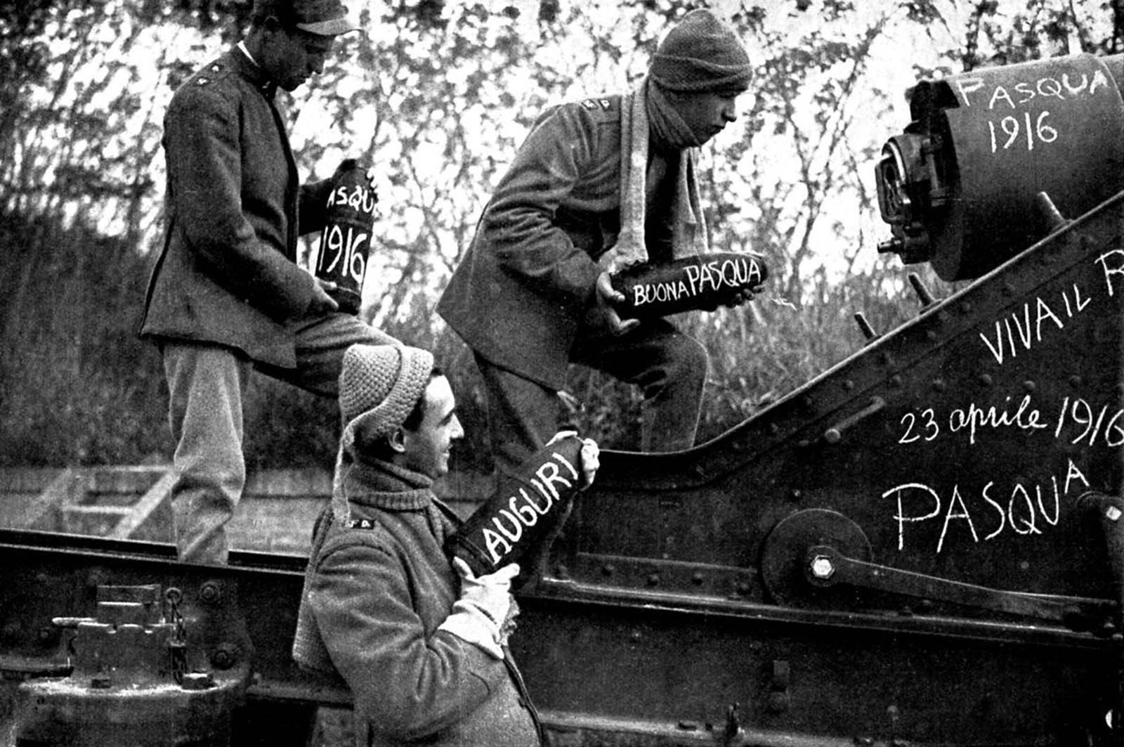 Italian artillery gunners load shells decorated with Easter messages. 1916.