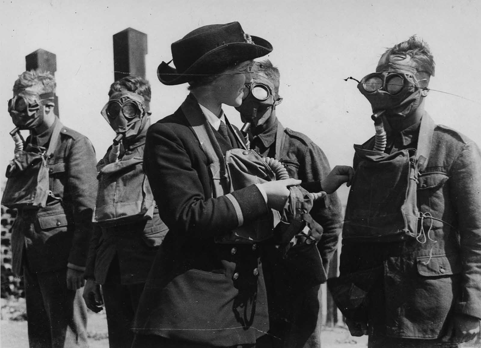 A Women's Royal Naval Service instructor drills recruits with gas masks.