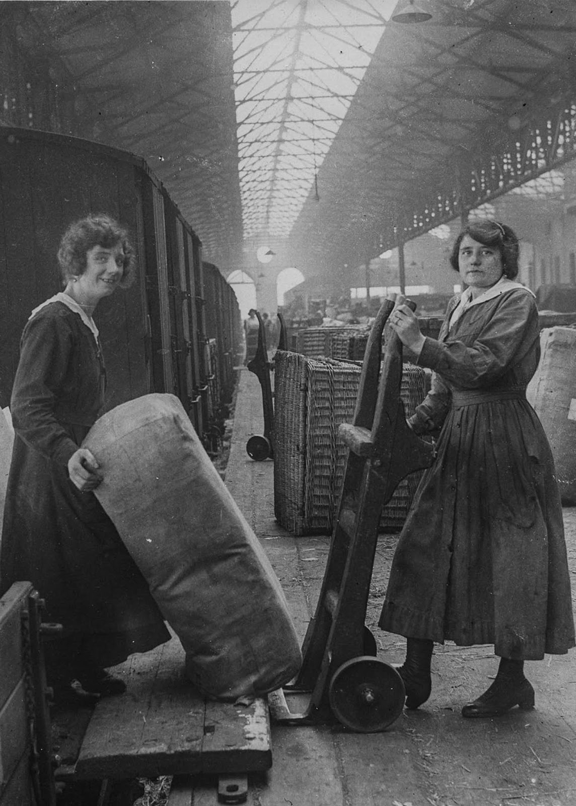 Railway workers unload goods from a train.