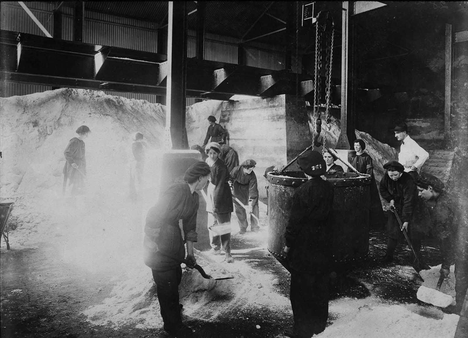 Workers shovel nitrate of soda into a skip.