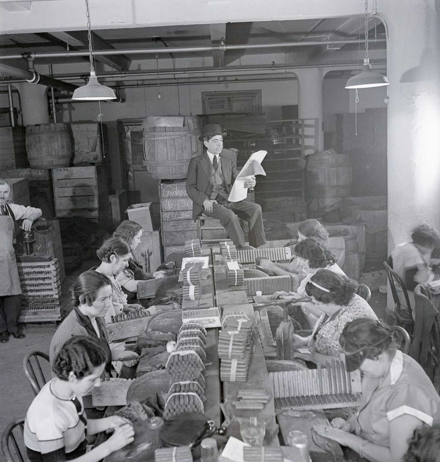 A lector reads a newspaper to workers in a cigar factory. 1900s.