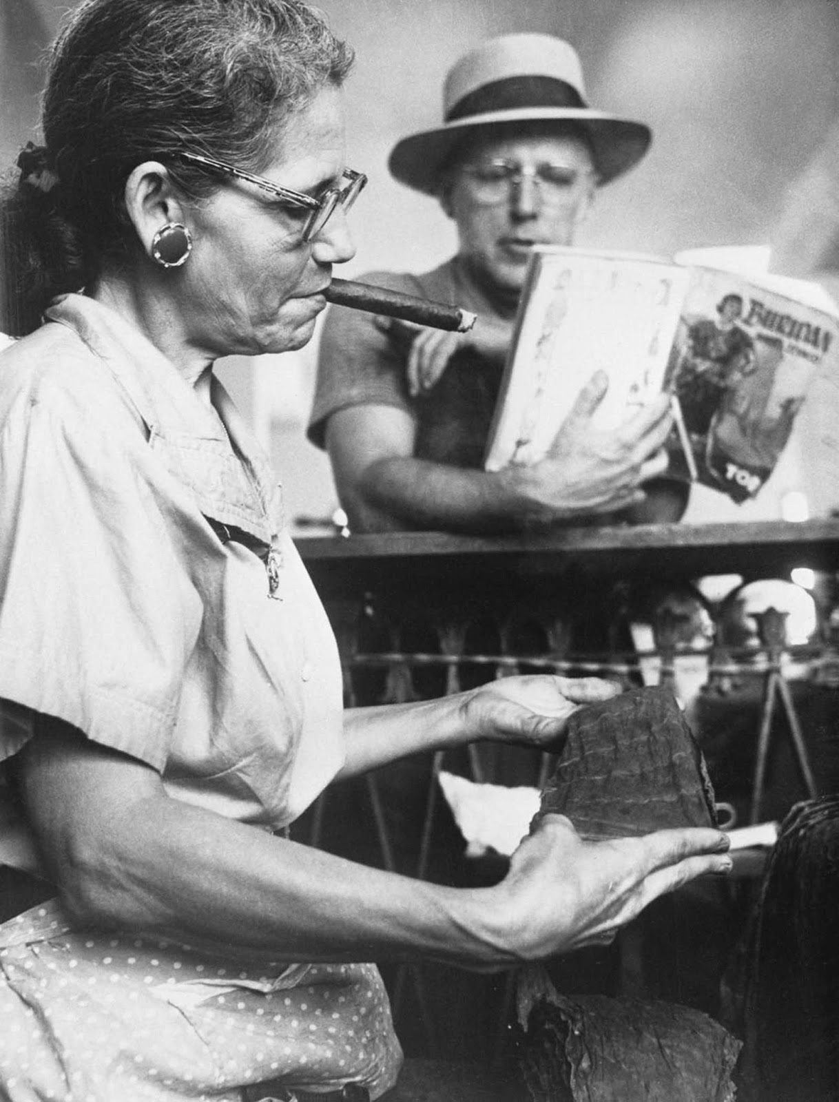 A lector reads a book to a worker in the Piedra Cigar factory in Maianao, Cuba. 1960.