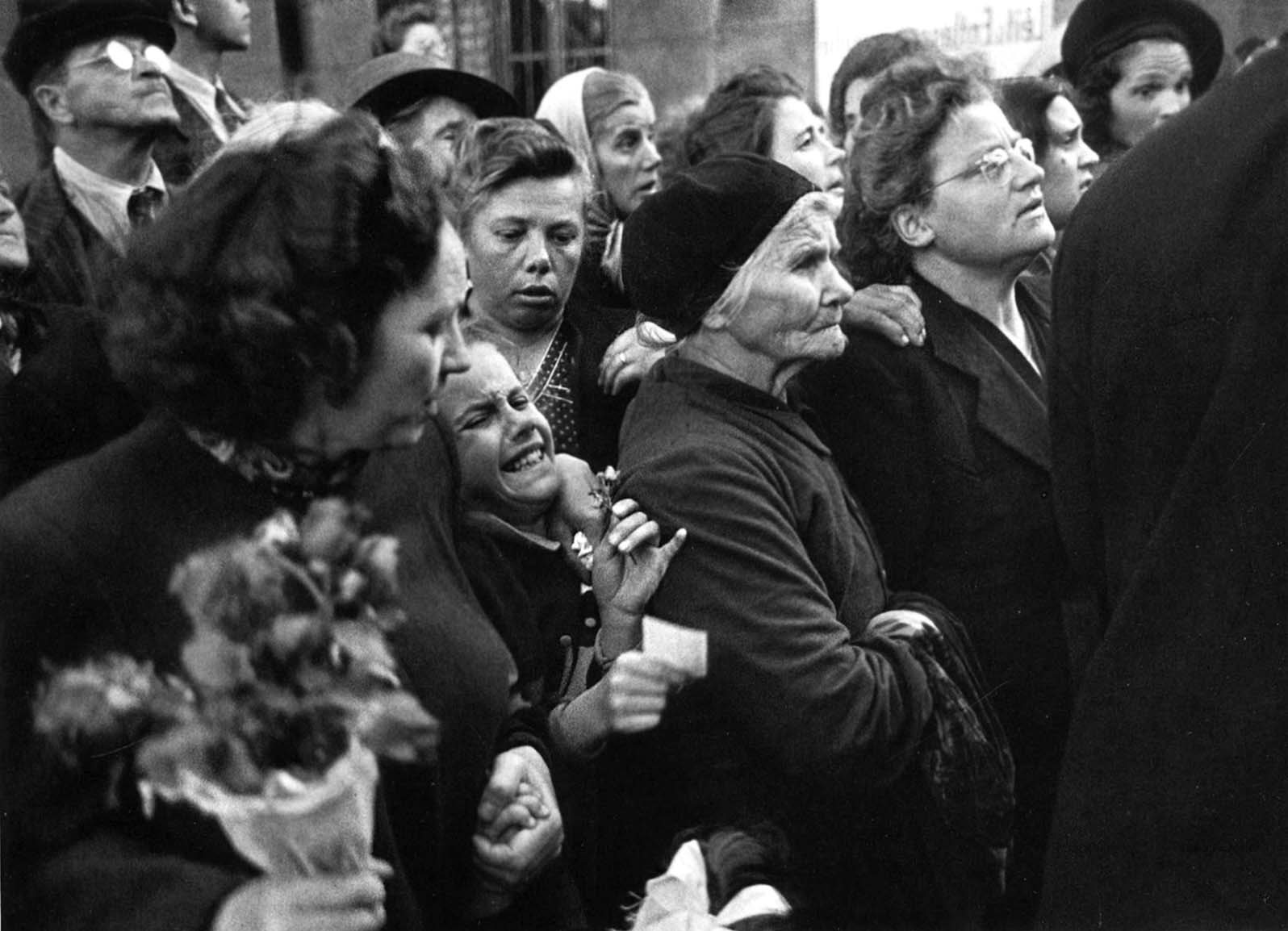 Crowds in Vienna waiting to greet homecoming prisoners show varying degrees of emotion ranging from stoicism to hysteria.