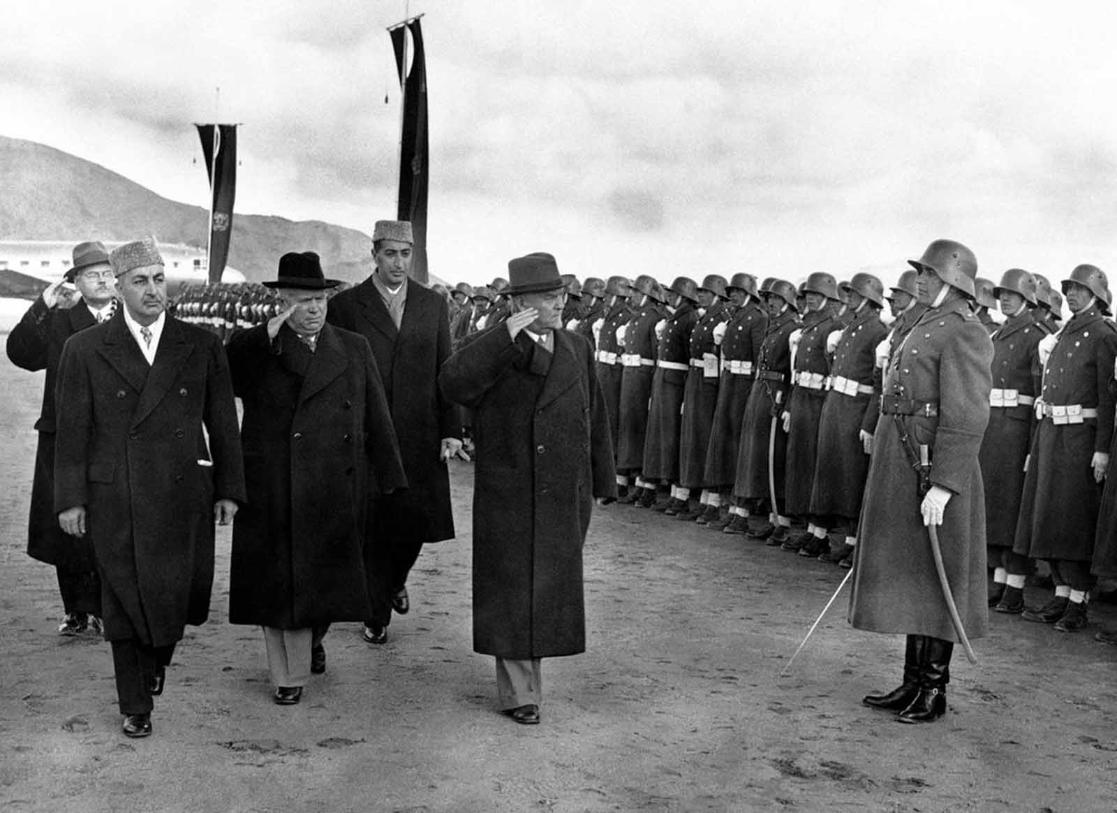 Soviet leader Nikita Khrushchev (black hat), and Marshal Nikolai Bulganin review an Afghan honor guard wearing old German uniforms, on their arrival in Kabul, Afghanistan, on December 15, 1955. At left is the Afghan Prime Minister Sardar Mohammed Daud Khan, and behind, in cap, the foreign minister, Prince Naim.