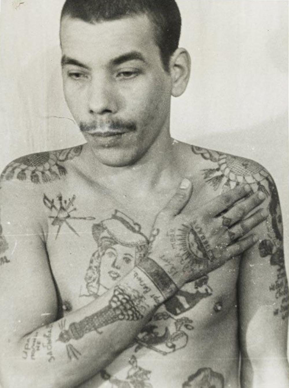 This man is a Muslim; his features also indicate he is not Russian. Text on the arm reads ‘Remember me, don’t forget me’ and ‘I waited 15 years for you.' On his stomach (left) is a religious building with a crescent moon. He is not an authoritative thief, but has tried to imitate them with his tattoos to increase his standing within the prison. The lighthouse on his right arm denotes a pursuit of freedom. Each wrist manacle indicates a sentence of more than five years in prison.