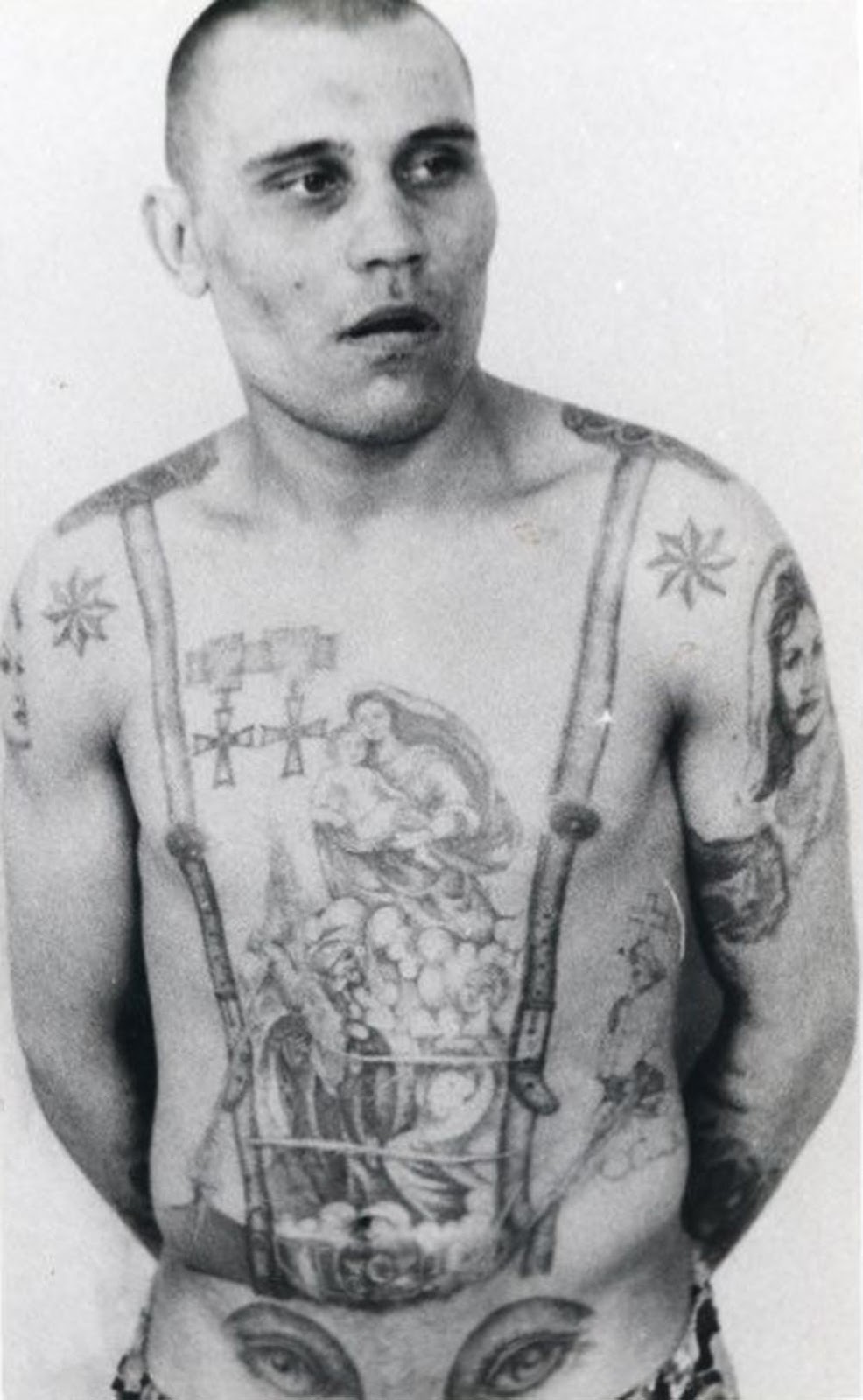 The stars on the shoulders show that this inmate is a criminal authority. The medals are awards that existed before the revolution and, as such, are signs of antagonism and defiance toward the Soviet regime. The eyes on the stomach denote a homosexual (the penis makes the ‘nose’ of the face).