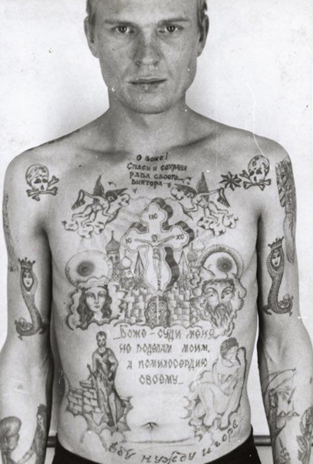 Text above the cross reads ‘O Lord, Save and Protect your servant Viktor.' Text beneath reads ‘God do not judge me by my deeds but by your mercy.' Text above the waist reads ‘I fuck poverty and misfortune.' The skull and crossbones show the prisoner is serving a life term. The single eight-pointed star denotes that he is a ‘semi-authority’ among thieves. The girl catching her dress with a fishing line on his left forearm is a tattoo worn by hooligans and rapists. The snake coiled around human remains (positioned on the middle third of each arm) is a variation on an old thieves’ tattoo. The snake is a symbol of temptation; here the snake’s head has been replaced by that of a woman, the temptress. Tattooed on the right side of the stomach is a version of Judith (1504) as painted by Giorgione; this is intended as a symbol of a scheming, seductive woman who betrays a noble man.