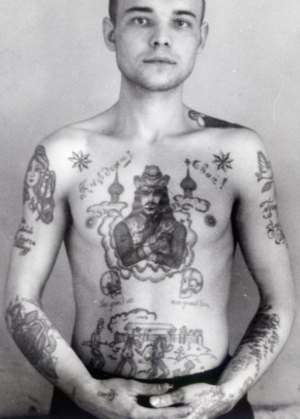 Text on the right arm reads ‘Save love, keep freedom.' Text on the left arm reads ‘Sinner.' Text across the chest reads ‘To each his own.' Text underneath the skulls reads ‘God against everyone, everyone against God.' Text on the wrist in German reads 'Mein Gott' (My God). A cowboy with a gun shows this thief is prepared to take risks and is ready to exploit any opportunity. A dove carrying a twig (left shoulder) is a symbol of good tidings and deliverance from suffering.
