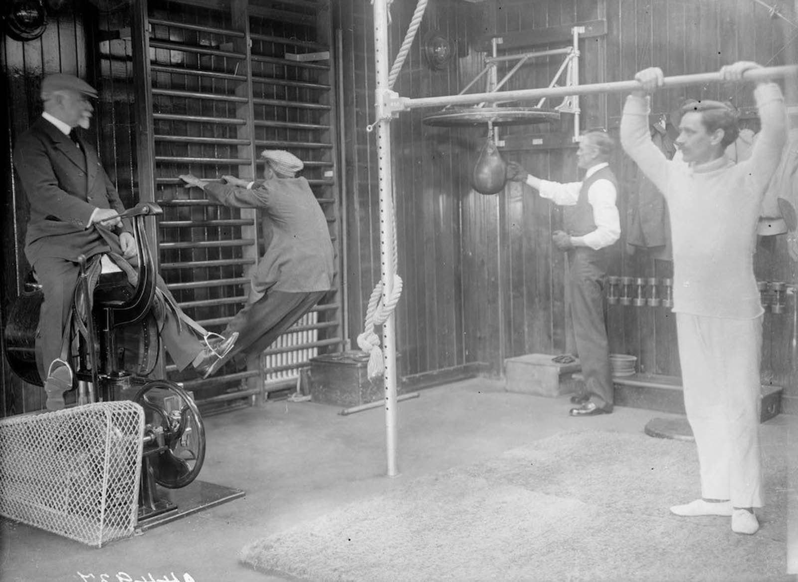 Passengers working out in the gym of the Cunard cruise liner Franconia, which was destroyed by a U-boat in 1916. Amongst the equipment is a punchbag and an early cycling machine. 1912.