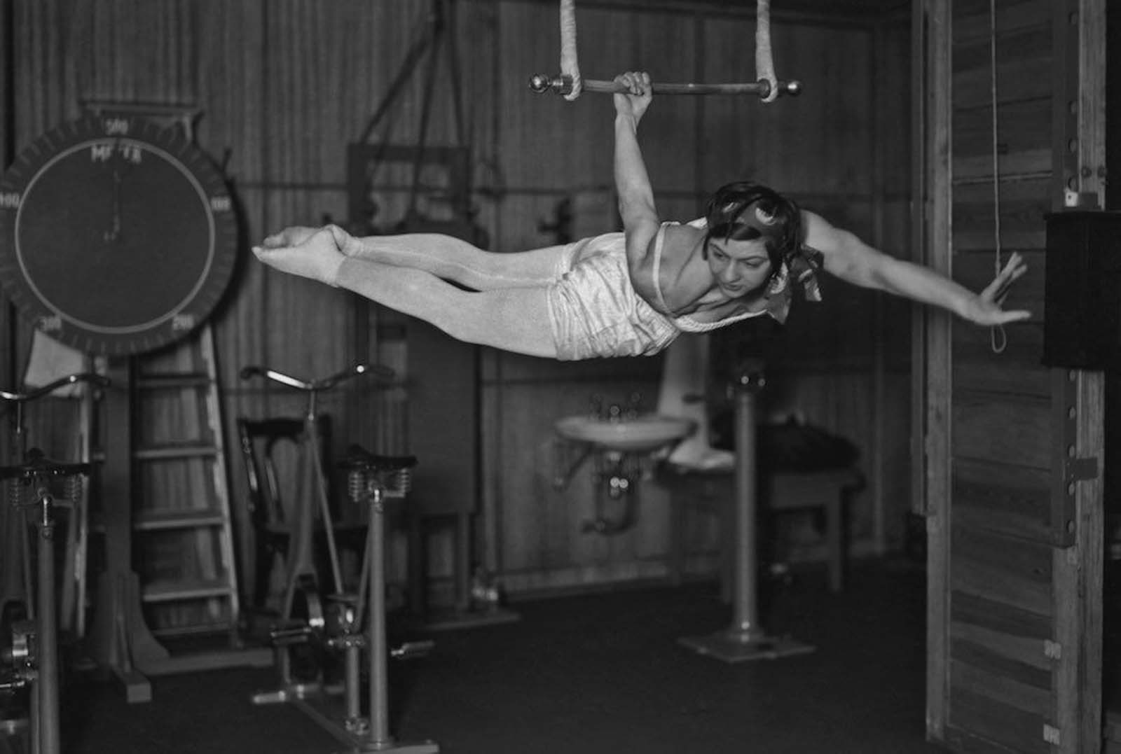 A woman using an apparatus in the gymnasium of the ocean liner S.S. Bremen. 1930s.