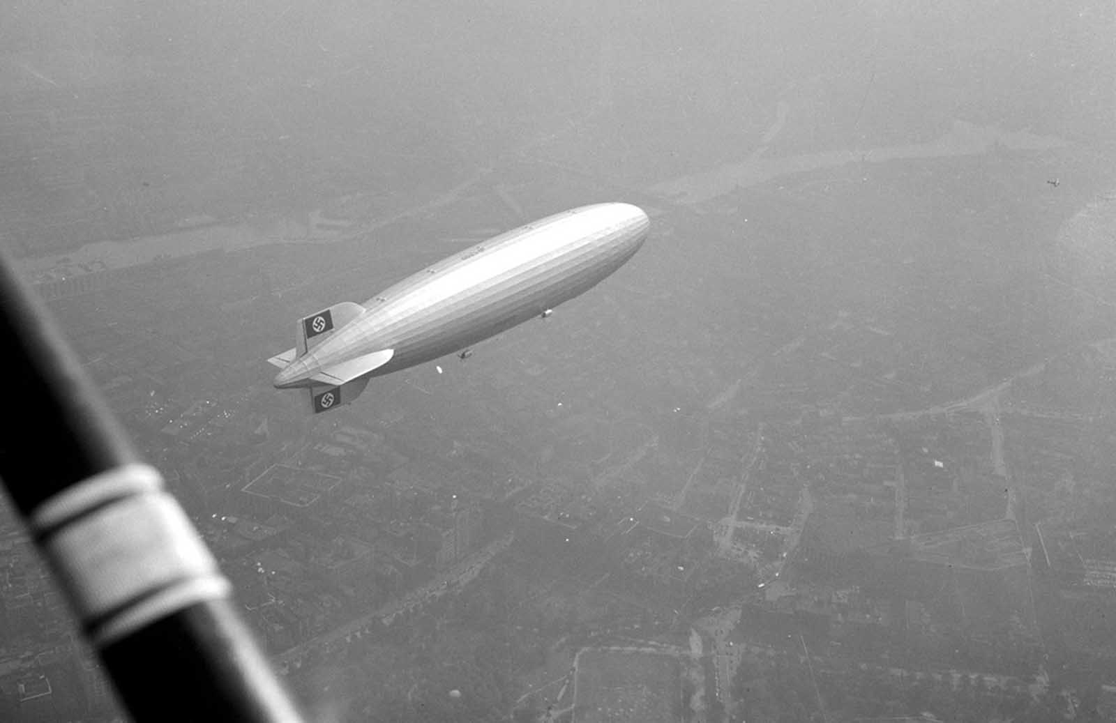 The Hindenburg flies over the Boston Common in Boston, Massachusetts in 1936. Another small plane can also be seen at top right.