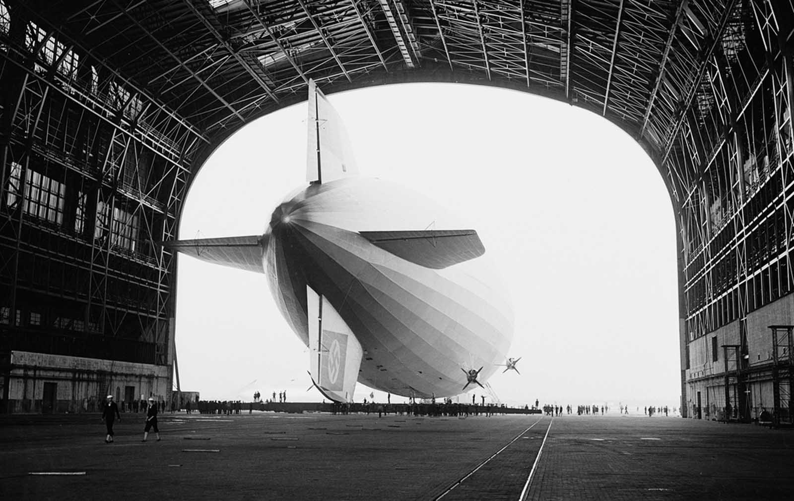 The German-built zeppelin Hindenburg is shown from behind, with the Swastika symbol on its tail wing, as the dirigible is partially enclosed by its hangar at the U.S. Navy Air Station in Lakehurst, New Jersey, May 9, 1936.